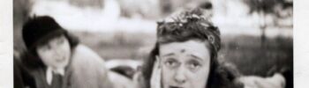 Black and white photo of a woman lying on a picnic blanket with a scraped forehead and nose making a sad face